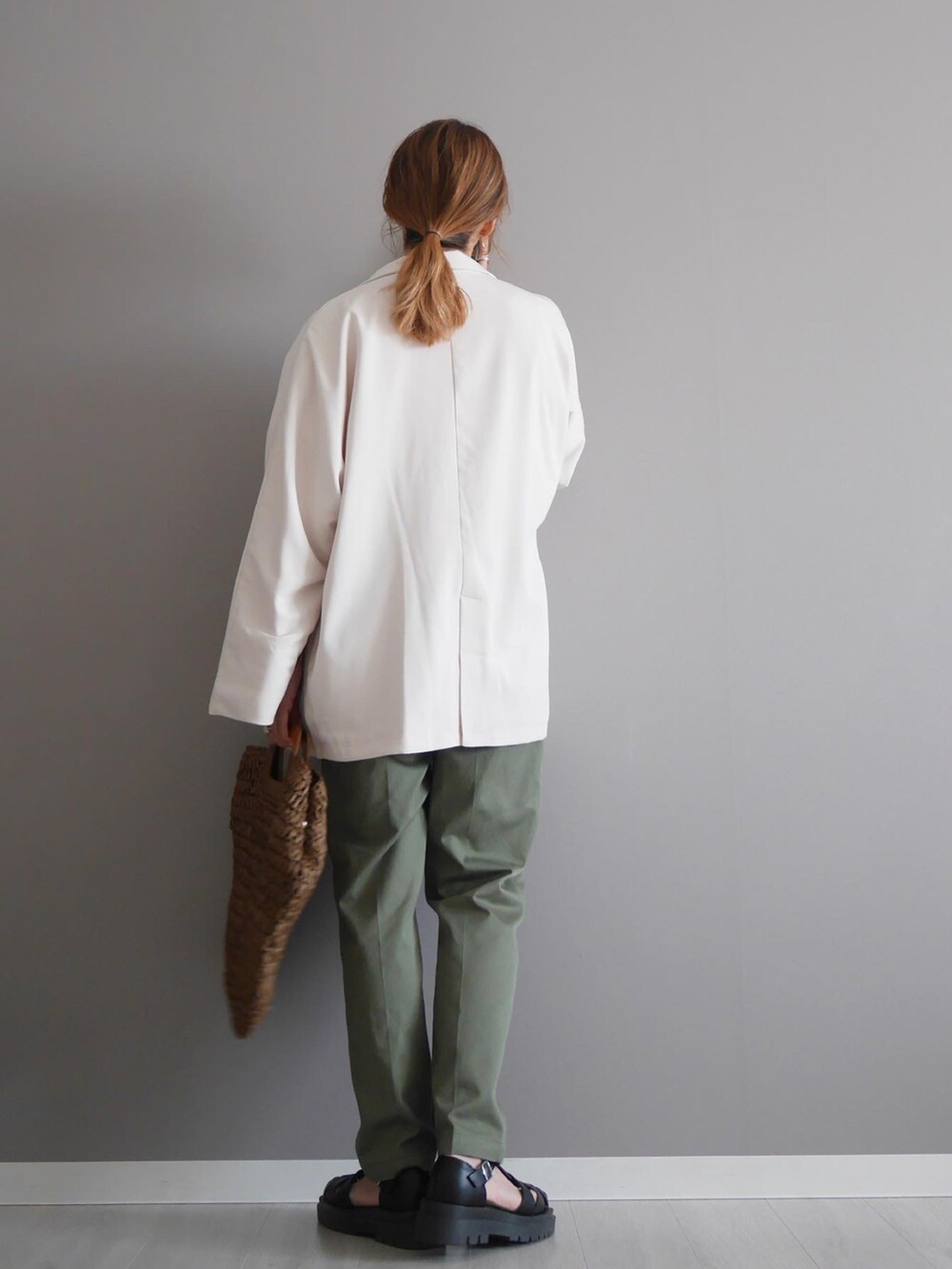 ブラウン系のかごバッグ、ホワイト系のTシャツ/カットソー、ホワイト系のテーラードジャケットを着用したレディースの春コーディネートの3枚目の写真