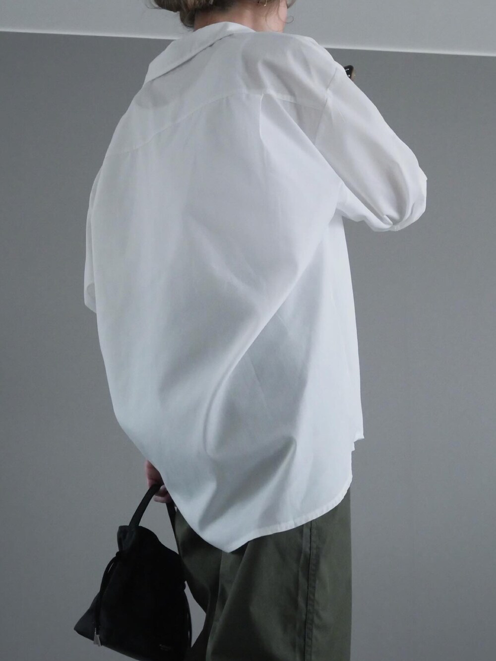 ホワイト系のシャツ/ブラウス、グリーン系のパンツ、ブラック系のバッグを着用したレディースの春コーディネートの2枚目の写真