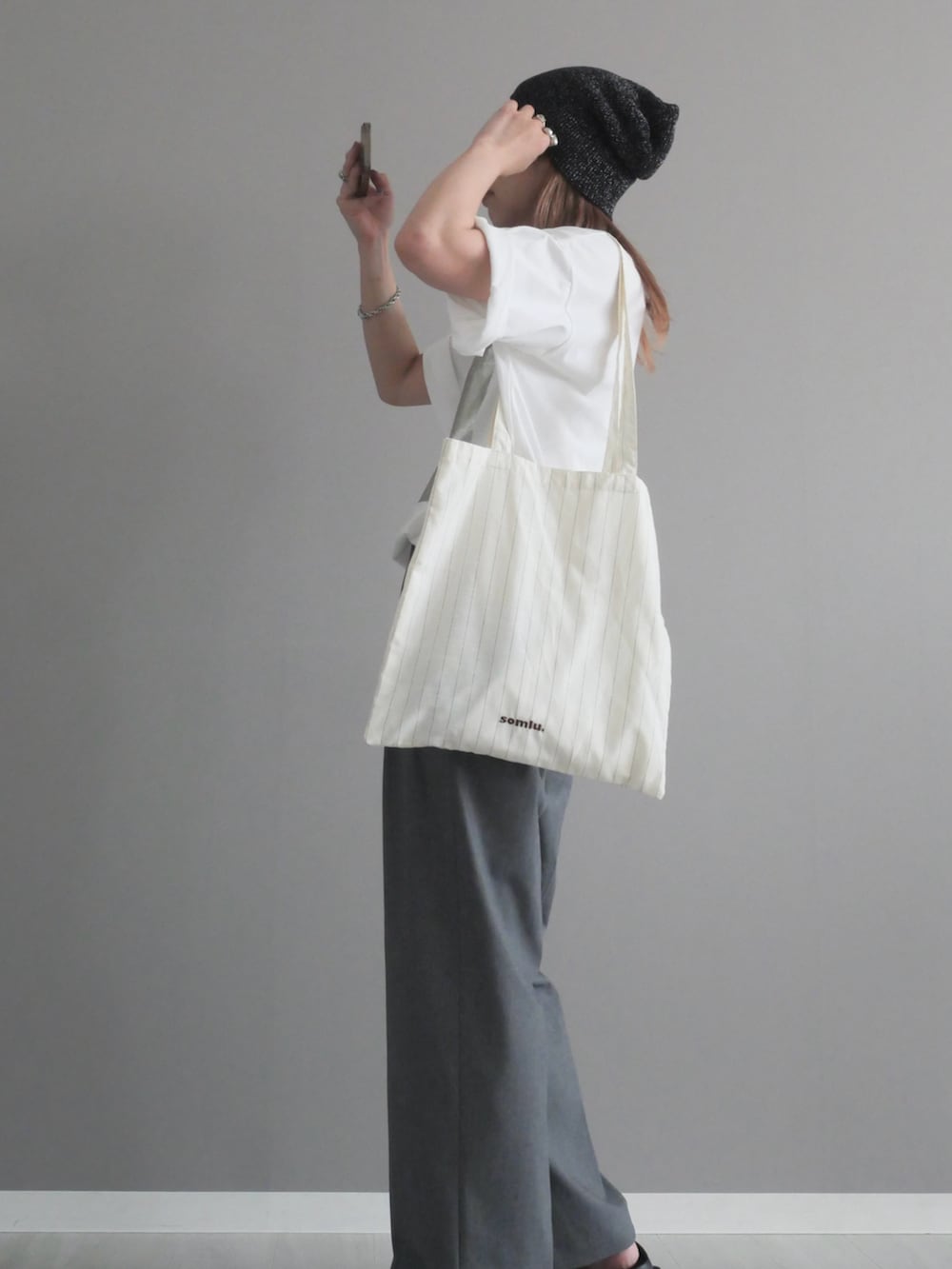 ホワイト系のTシャツ/カットソー、ホワイト系のトートバッグ、ブラック系のニットキャップ/ビーニーを着用したレディースの夏コーディネートの3枚目の写真