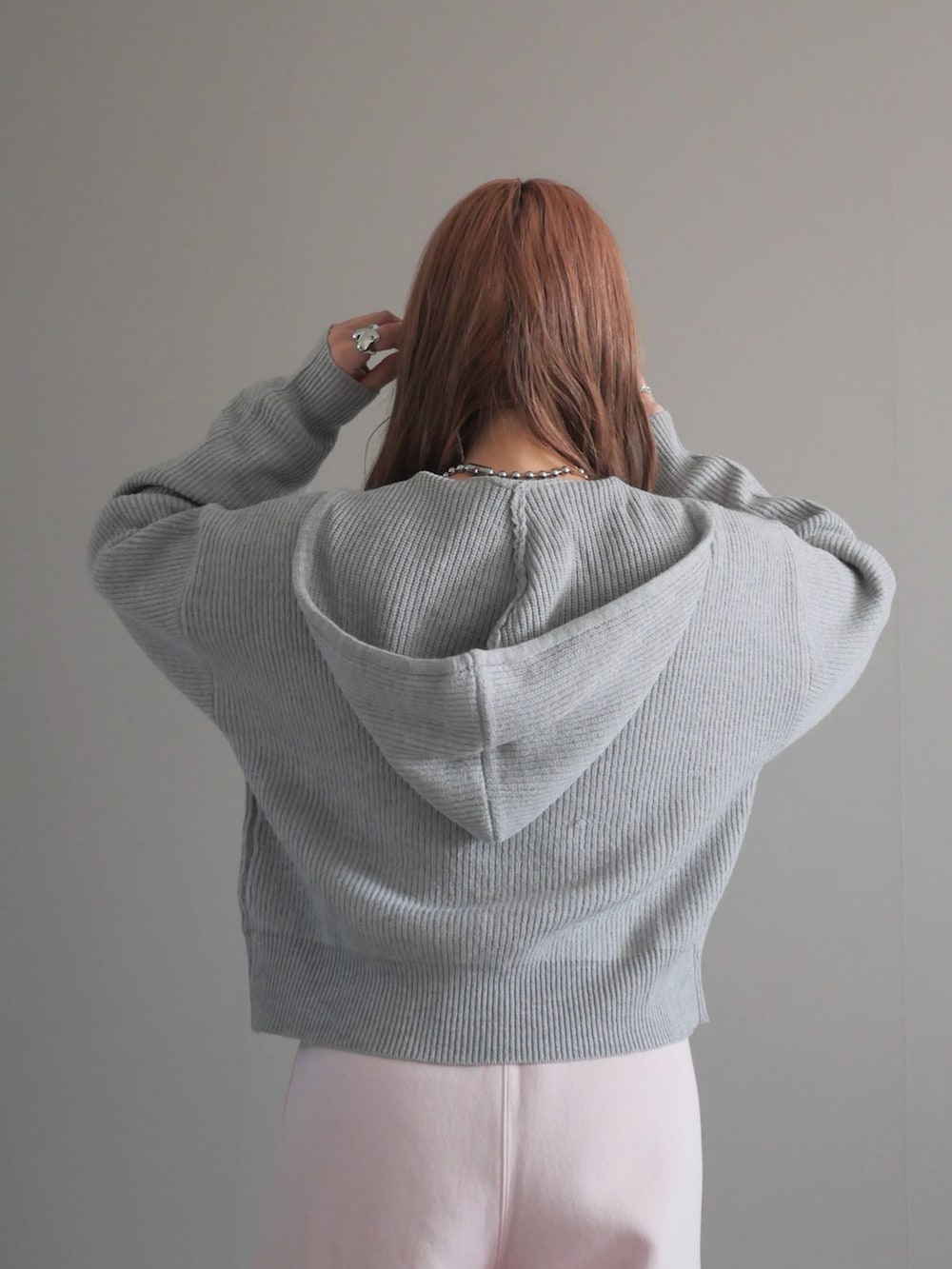 グレー系のパーカー、シルバー系のボディバッグ/ウエストポーチを着用したレディースの冬コーディネートの3枚目の写真