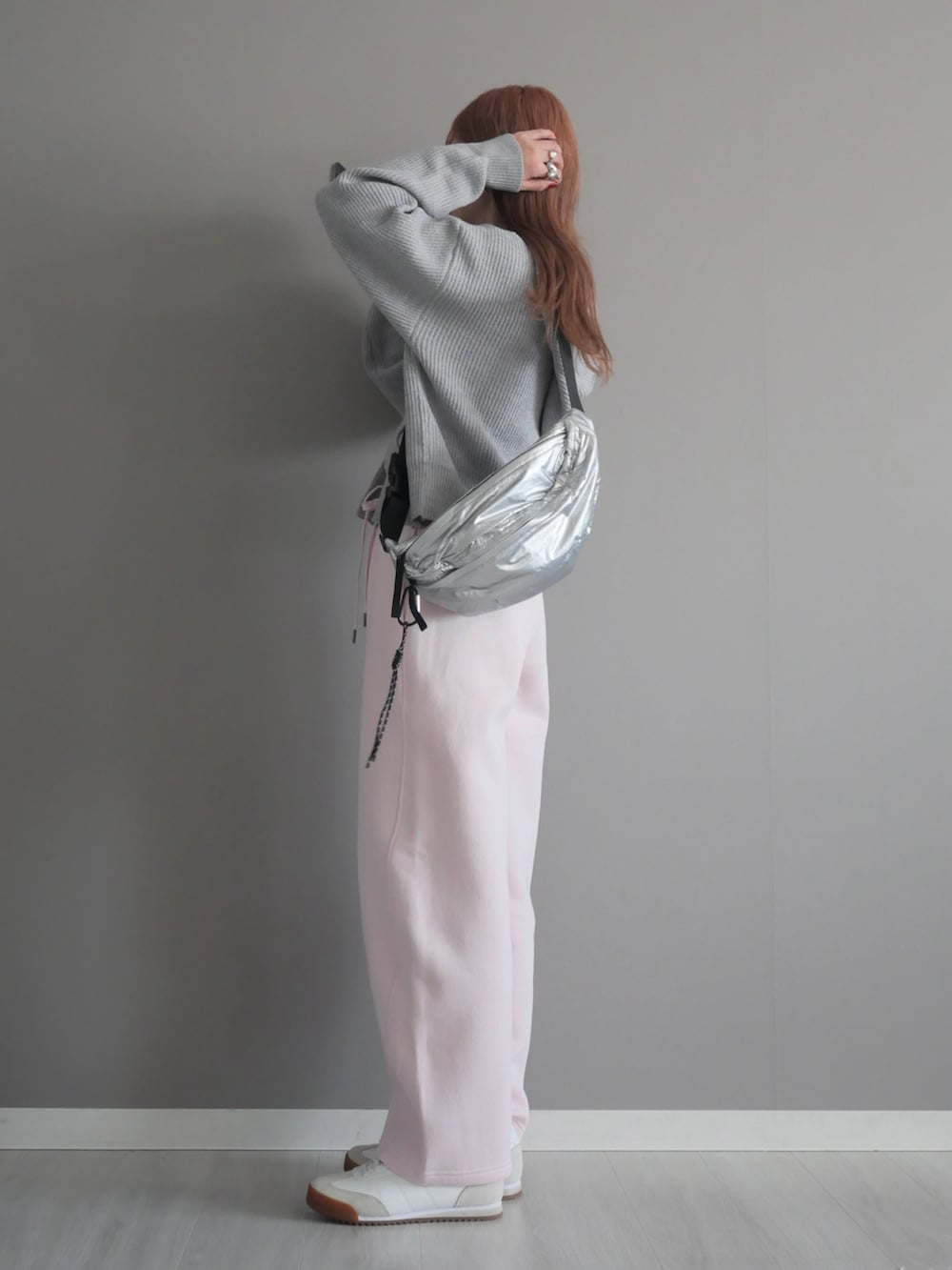 グレー系のパーカー、シルバー系のボディバッグ/ウエストポーチを着用したレディースの冬コーディネートの4枚目の写真