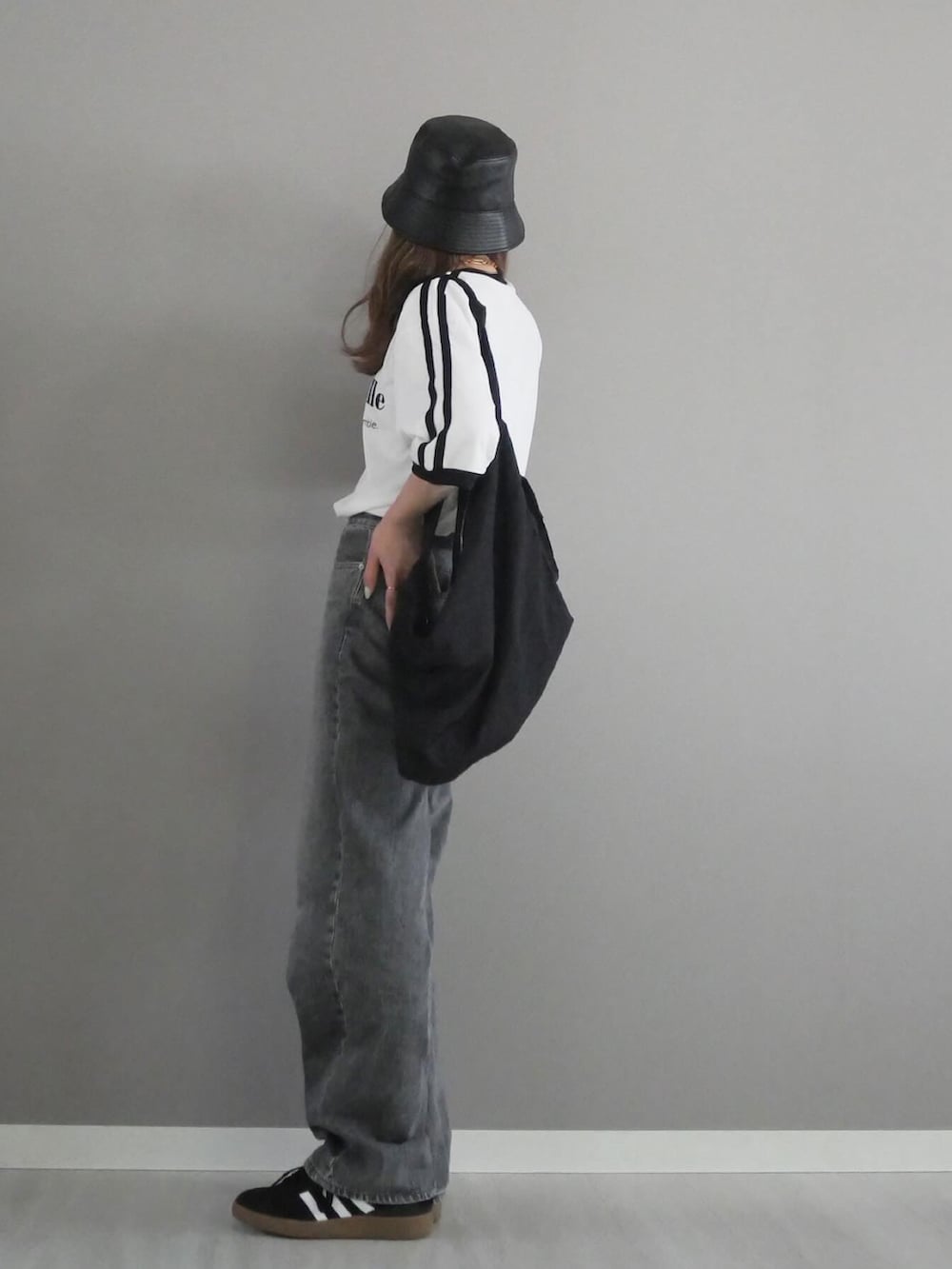 ホワイト系のTシャツ/カットソー、グレー系のデニムパンツ、ブラック系のショルダーバッグを着用したレディースの春コーディネートの2枚目の写真