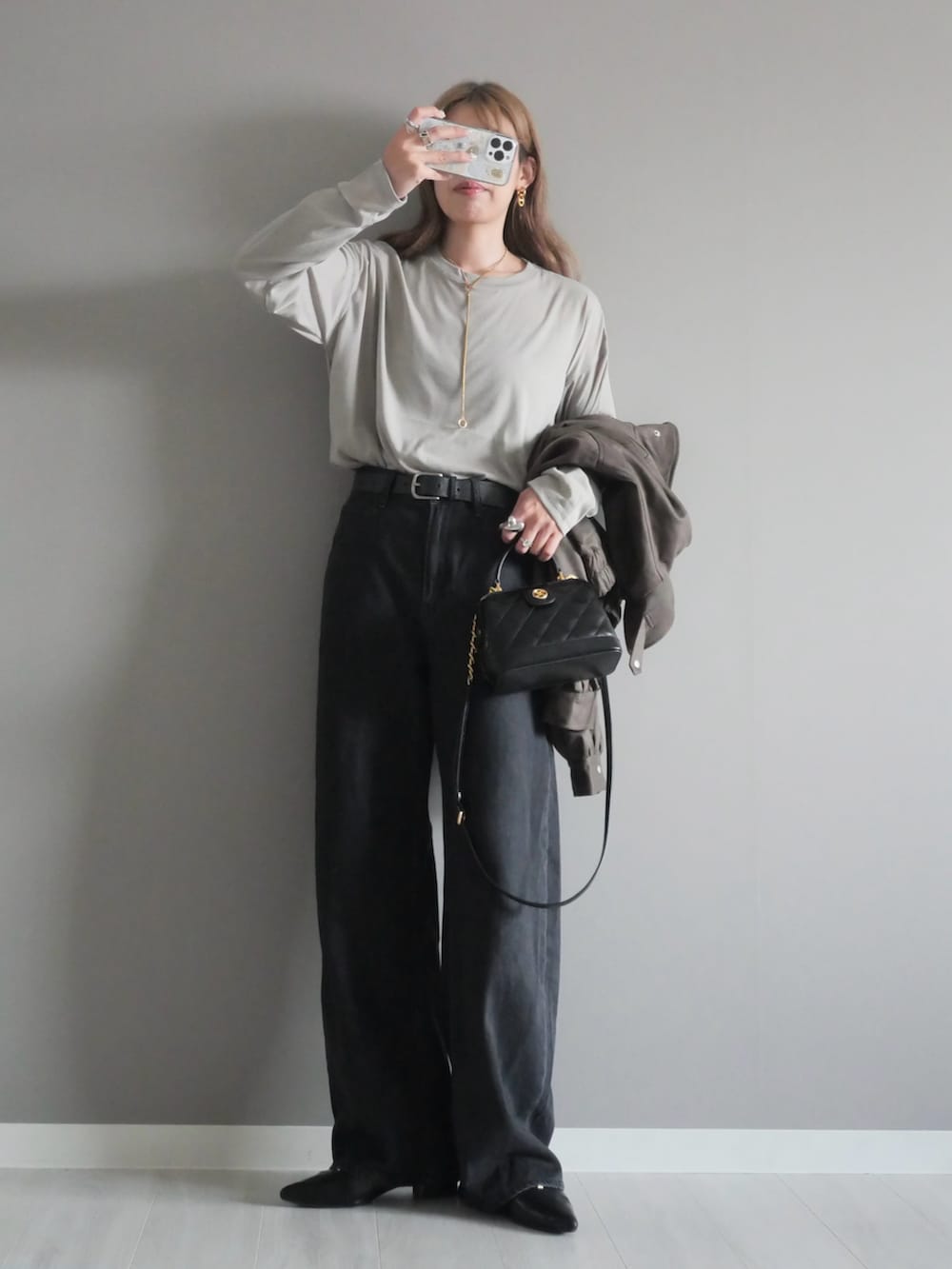 ブラウン系のブルゾン、ブラック系のトートバッグ、ブラック系のパンプスを着用したレディースの秋コーディネートの3枚目の写真