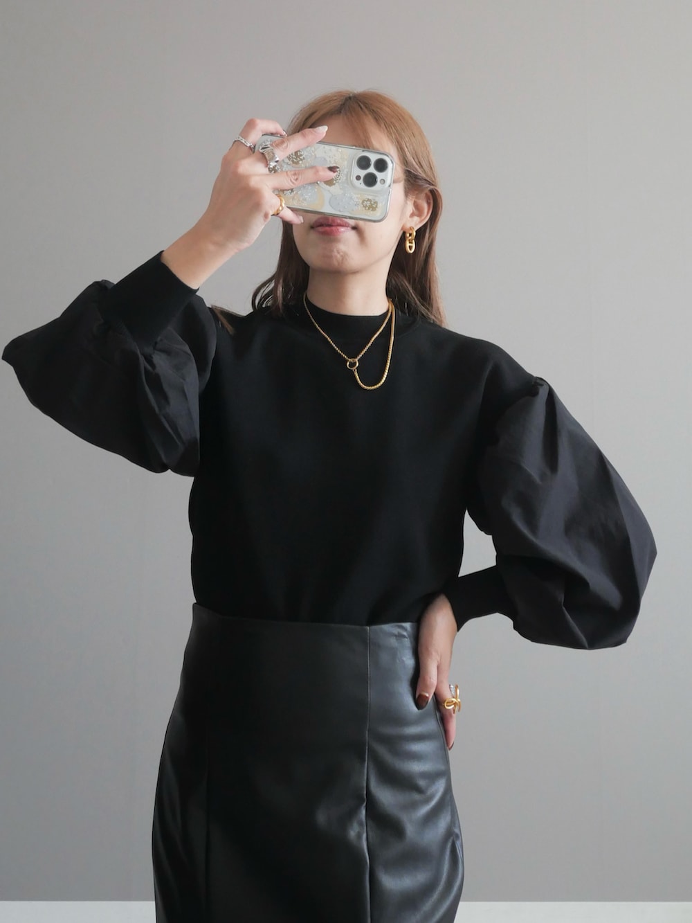 ブラック系のニット/セーター、ブラック系のショルダーバッグ、ブラック系のスカートを着用したレディースの秋コーディネートの2枚目の写真