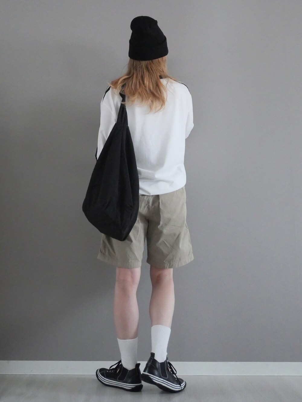 ブラック系のスニーカー、ホワイト系のTシャツ/カットソー、ベージュ系のパンツを着用したレディースの春コーディネートの4枚目の写真