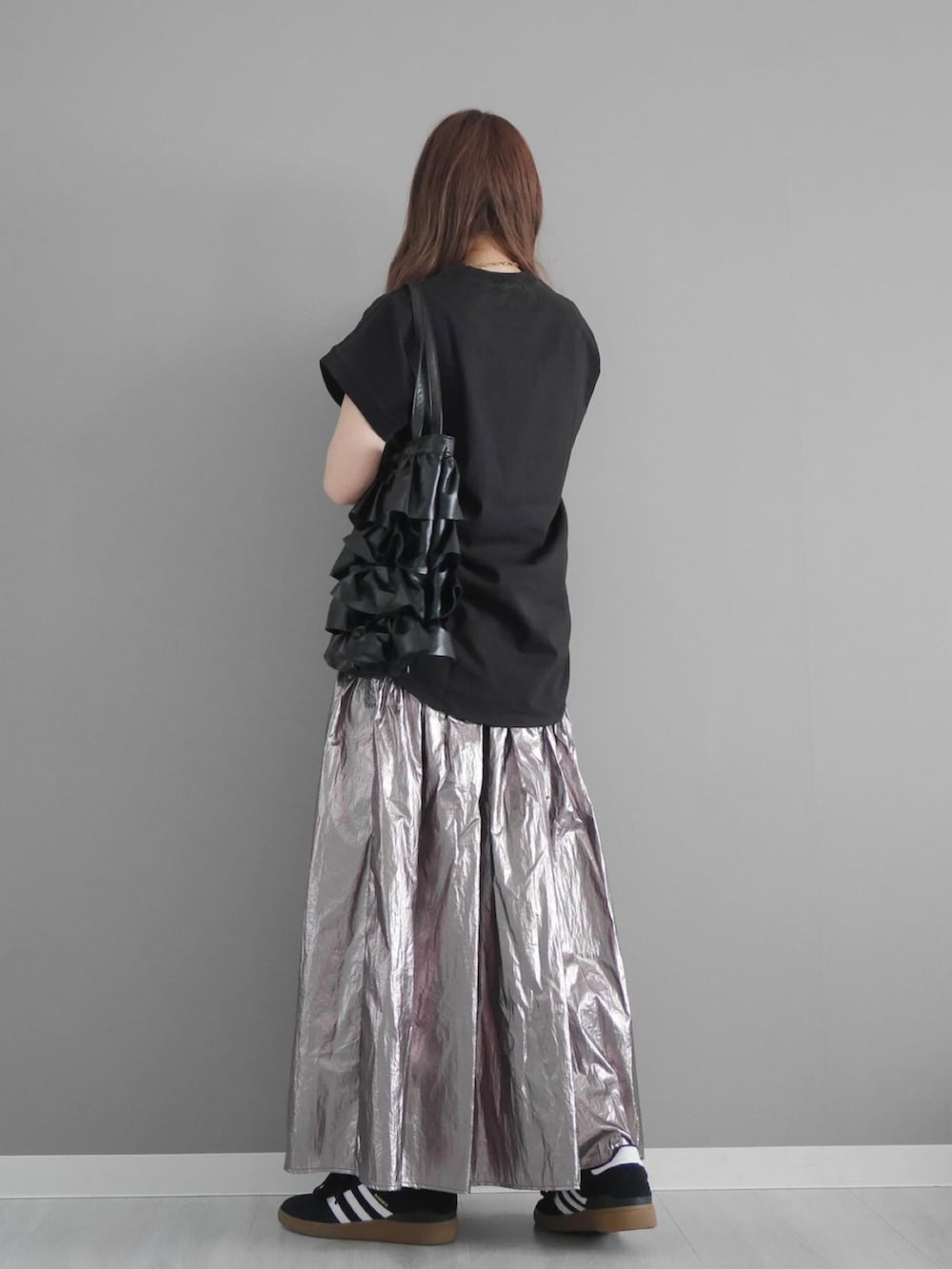 ブラック系のTシャツ/カットソー、シルバー系のスカート、ブラック系のトートバッグを着用したレディースの春コーディネートの3枚目の写真