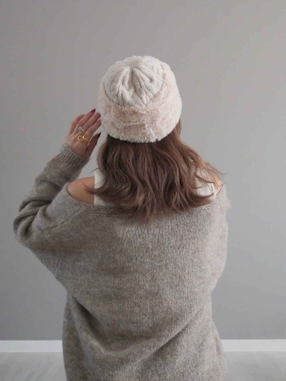 ブルー系のデニムパンツ、ベージュ系のニット/セーター、イエロー系のショルダーバッグを着用したレディースの冬コーディネートの4枚目の写真