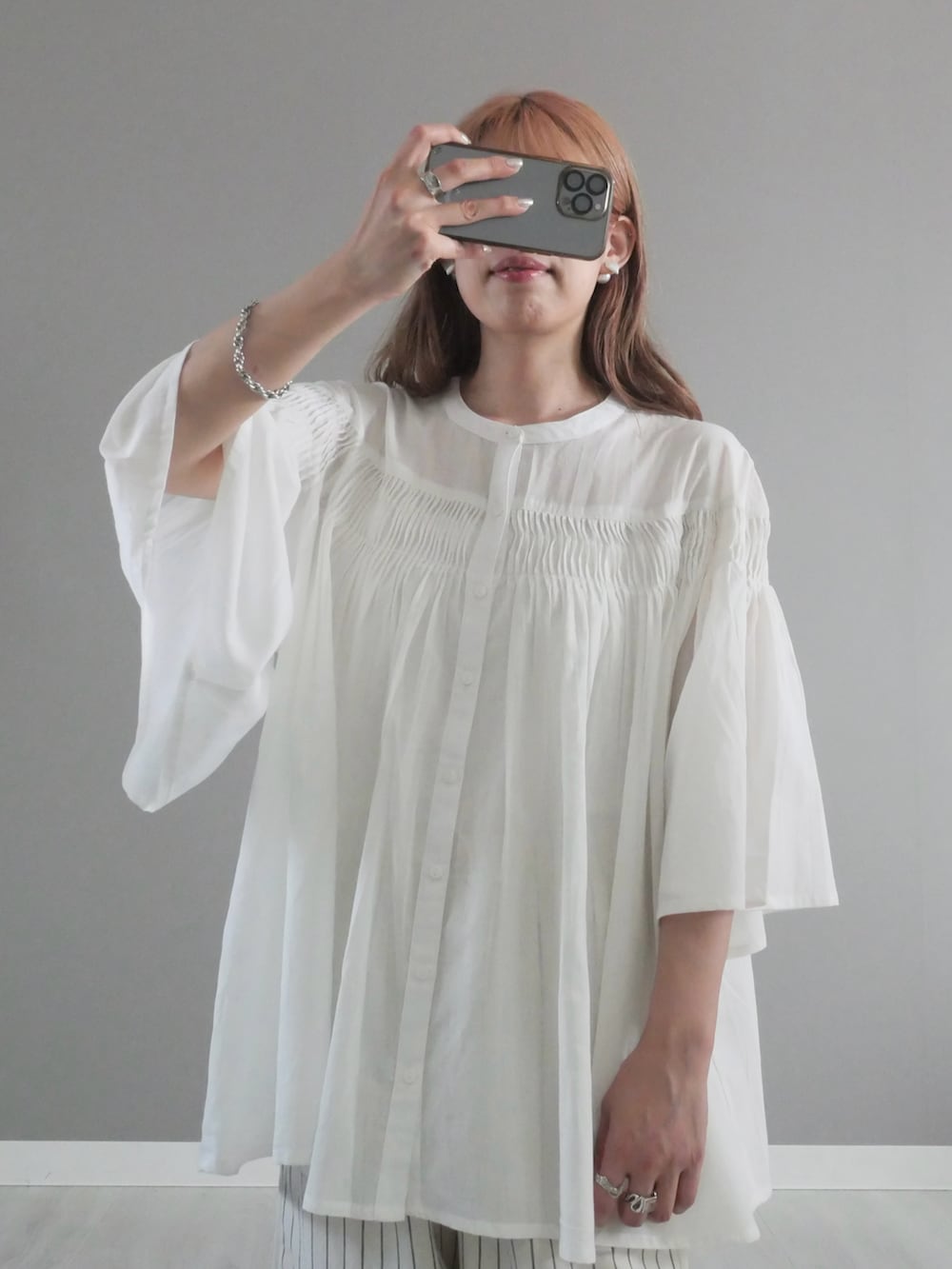 ホワイト系のパンツ、ベージュ系のかごバッグ、ホワイト系のサンダルを着用したレディースの夏コーディネートの2枚目の写真