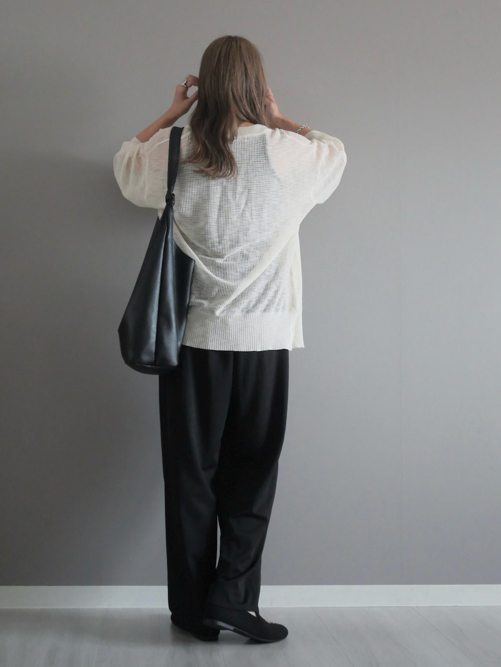 ホワイト系のカーディガン/ボレロ、ブラック系のタンクトップ、ブラック系のスラックスを着用したレディースの秋コーディネートの3枚目の写真