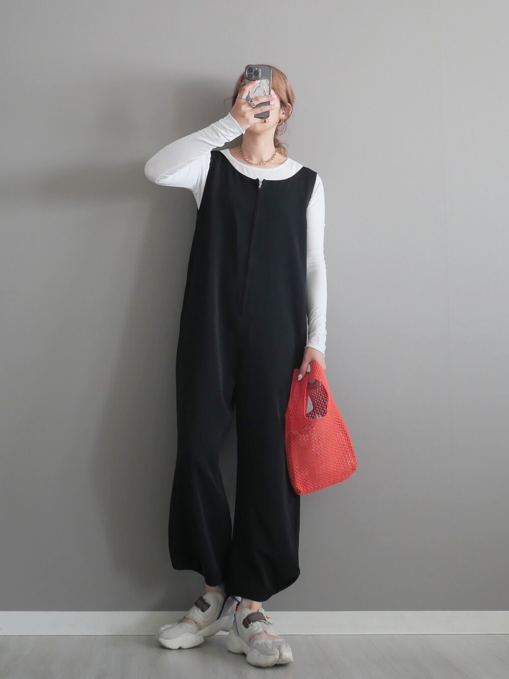 ブラック系のサロペット/オーバーオール、ホワイト系のTシャツ/カットソー、ゴールド系のネックレスを着用したレディースの春コーディネートの3枚目の写真