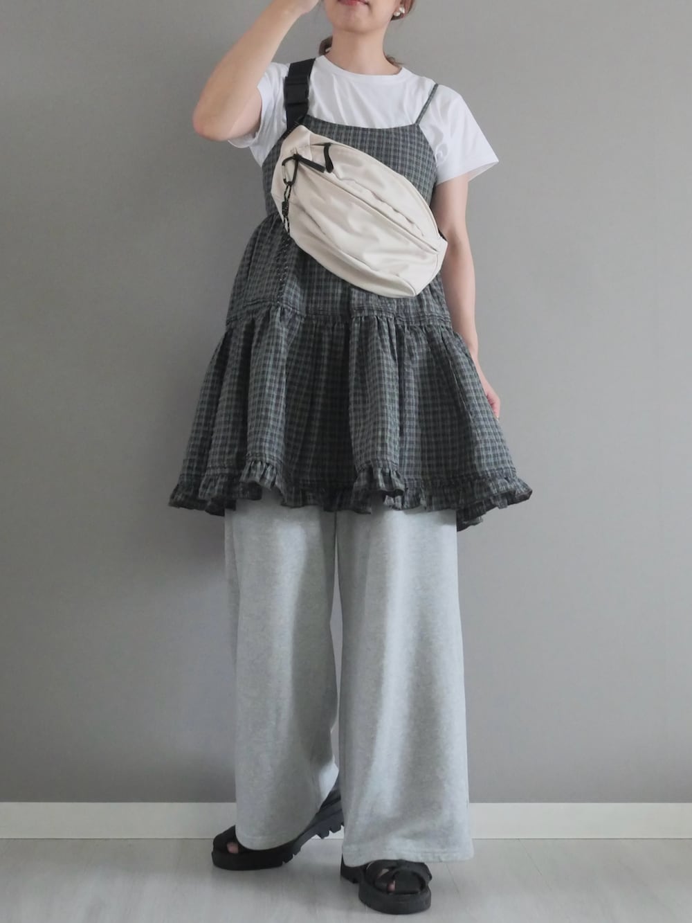 グレー系のワンピース、ホワイト系のボディバッグ/ウエストポーチ、ホワイト系のTシャツ/カットソーを着用したレディースの夏コーディネートの3枚目の写真