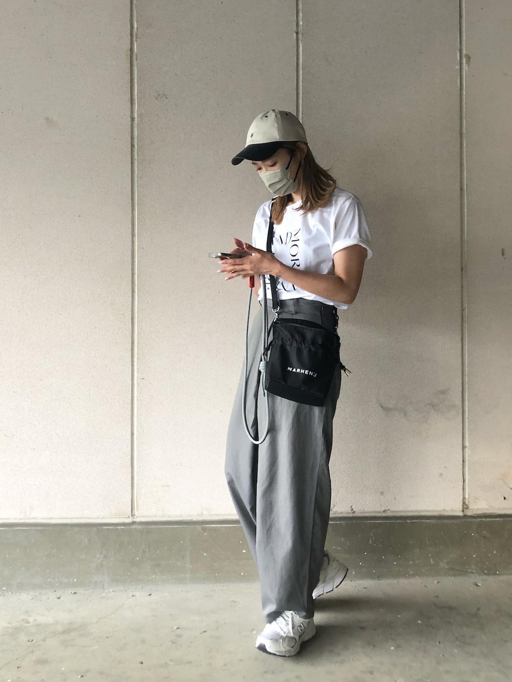 グレー系のスラックス、ホワイト系のTシャツ/カットソー、ブラック系のバッグを着用したレディースの夏コーディネートの3枚目の写真