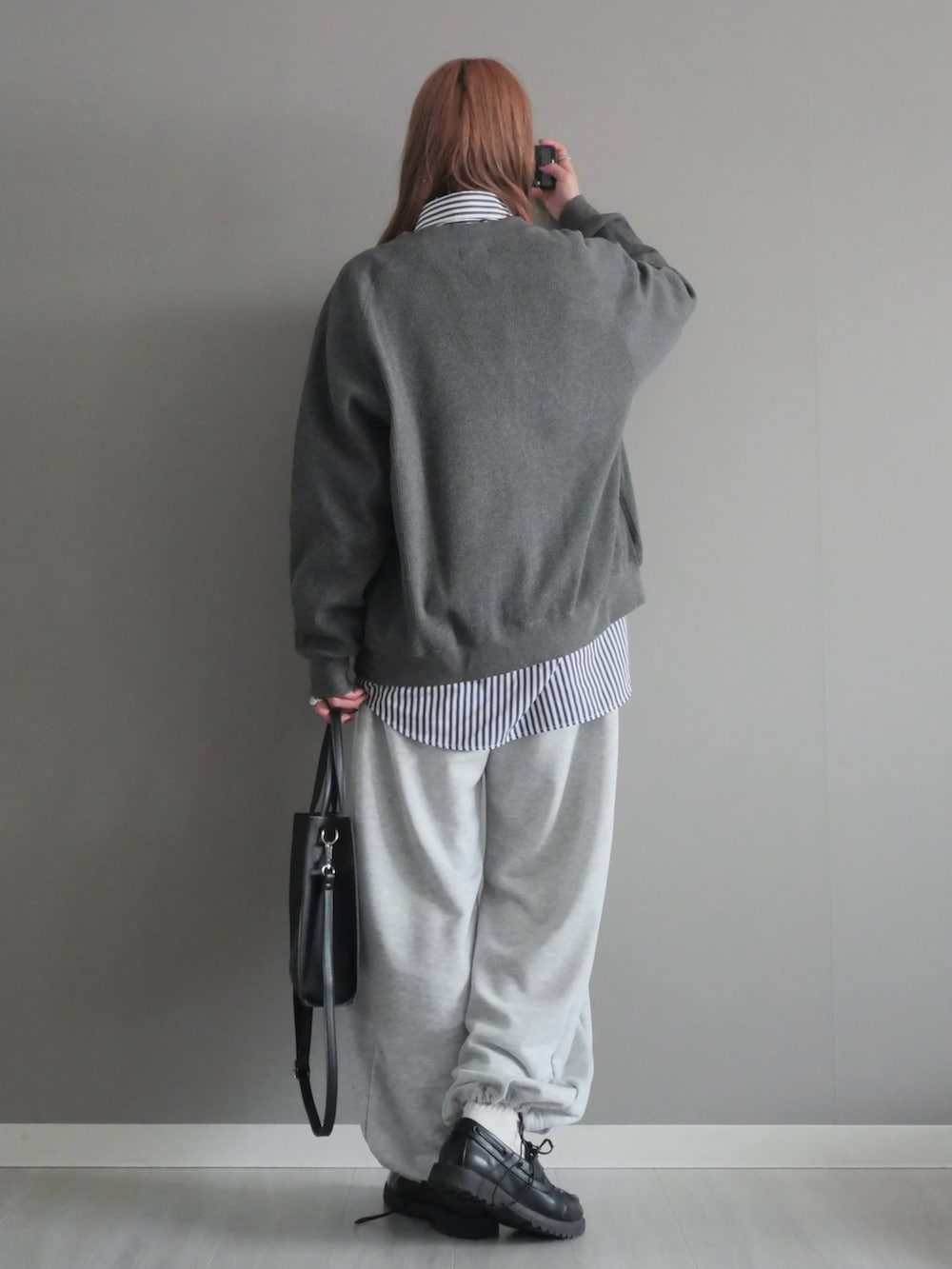 グレー系のカーディガン/ボレロ、グレー系のスウェットパンツ、ブラック系のショルダーバッグを着用したレディースの冬コーディネートの5枚目の写真