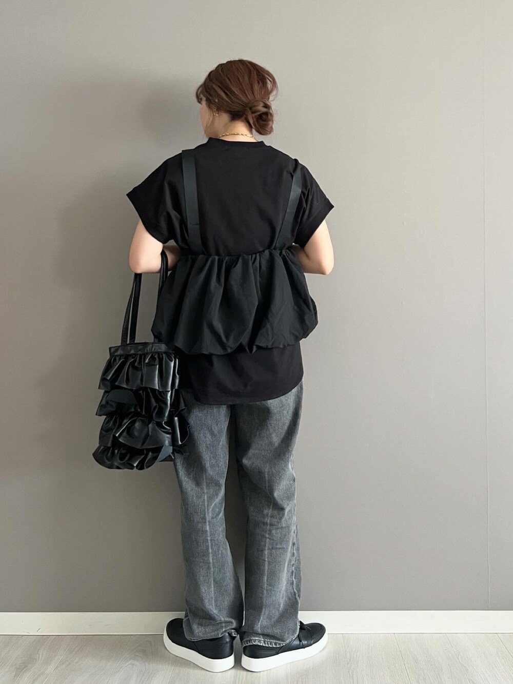 ブラック系のTシャツ/カットソー、ブラック系のベスト、グレー系のデニムパンツを着用したレディースの春コーディネートの2枚目の写真