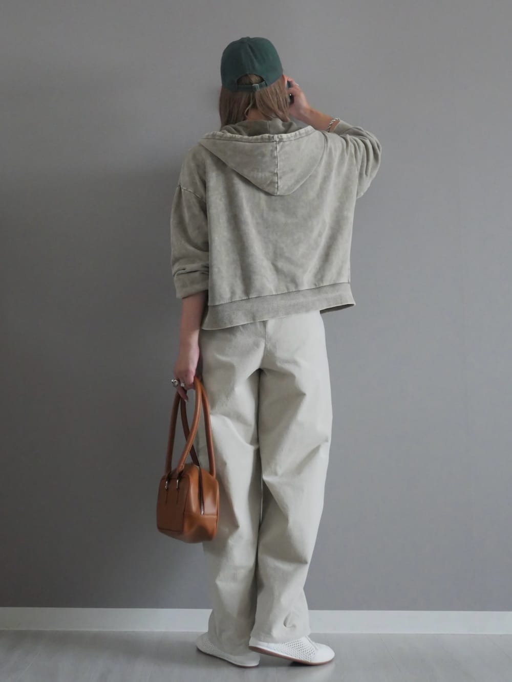 グレー系のパーカー、イエロー系のボストンバッグ、シルバー系のネックレスを着用したレディースの秋コーディネートの3枚目の写真