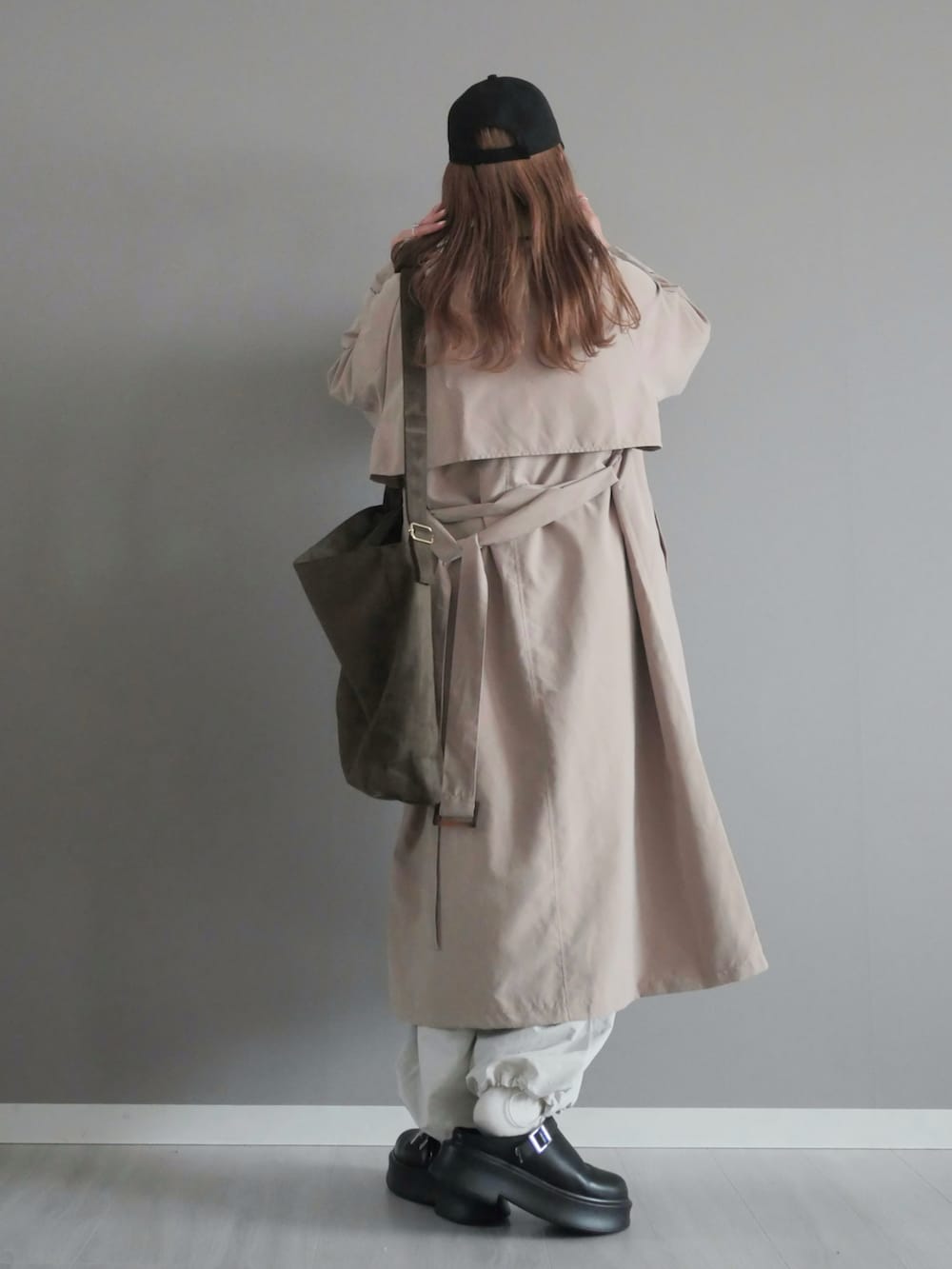 ベージュ系のトレンチコート、グリーン系のショルダーバッグ、ブラック系のスリッポンを着用したレディースの春コーディネートの5枚目の写真