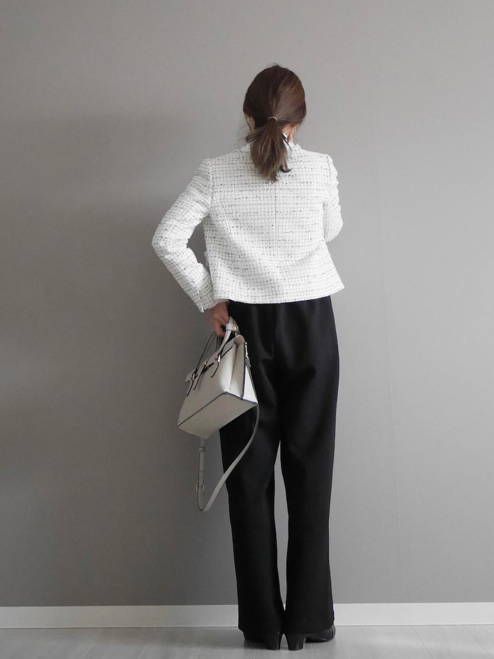 ブルー系のノーカラージャケット、ブラック系のサロペット/オーバーオール、ホワイト系のトップスを着用したレディースの冬コーディネートの2枚目の写真