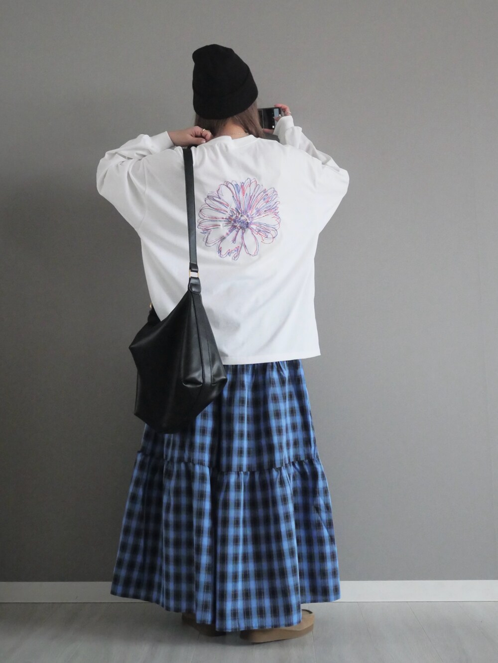 ホワイト系のTシャツ/カットソー、ブルー系のスカート、ブラック系のショルダーバッグを着用したレディースの春コーディネートの4枚目の写真