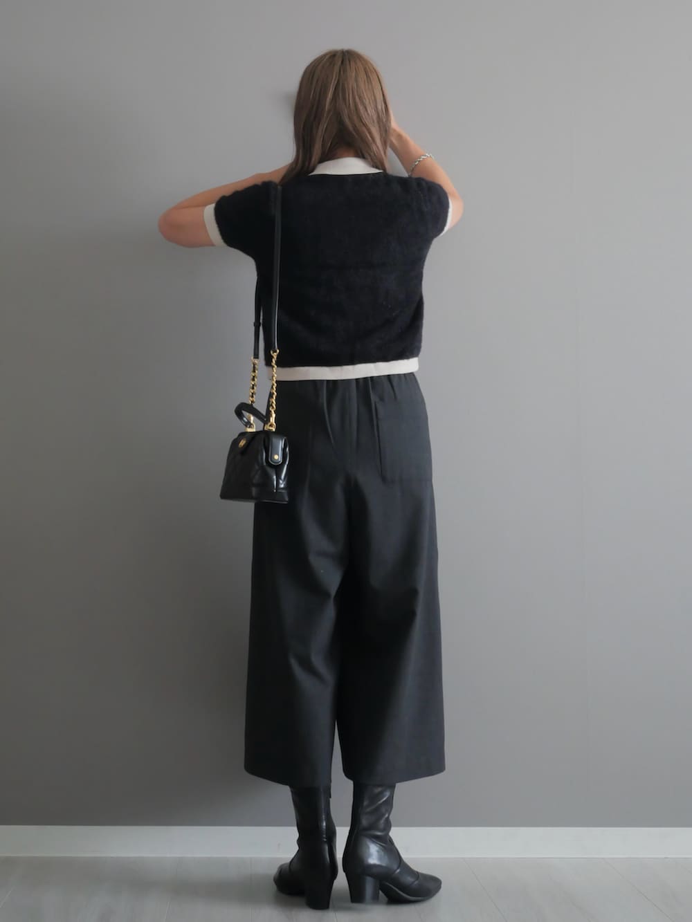 ブラック系のトートバッグ、ブラック系のブーツ、ブラック系のニット/セーターを着用したレディースの秋コーディネートの5枚目の写真