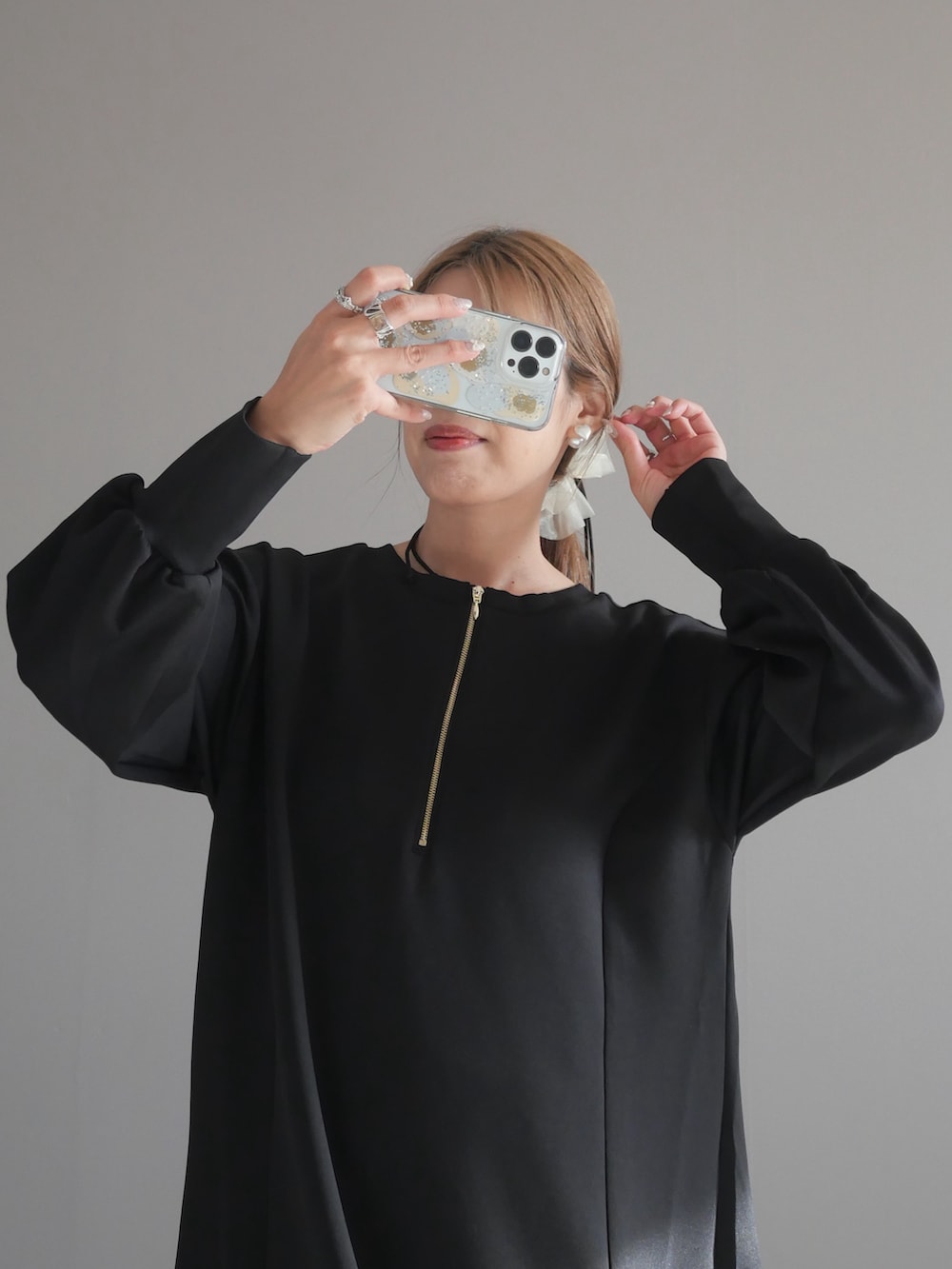 ブラック系のトートバッグ、ブラック系のワンピース、ブラック系のブーツを着用したレディースの秋コーディネートの3枚目の写真