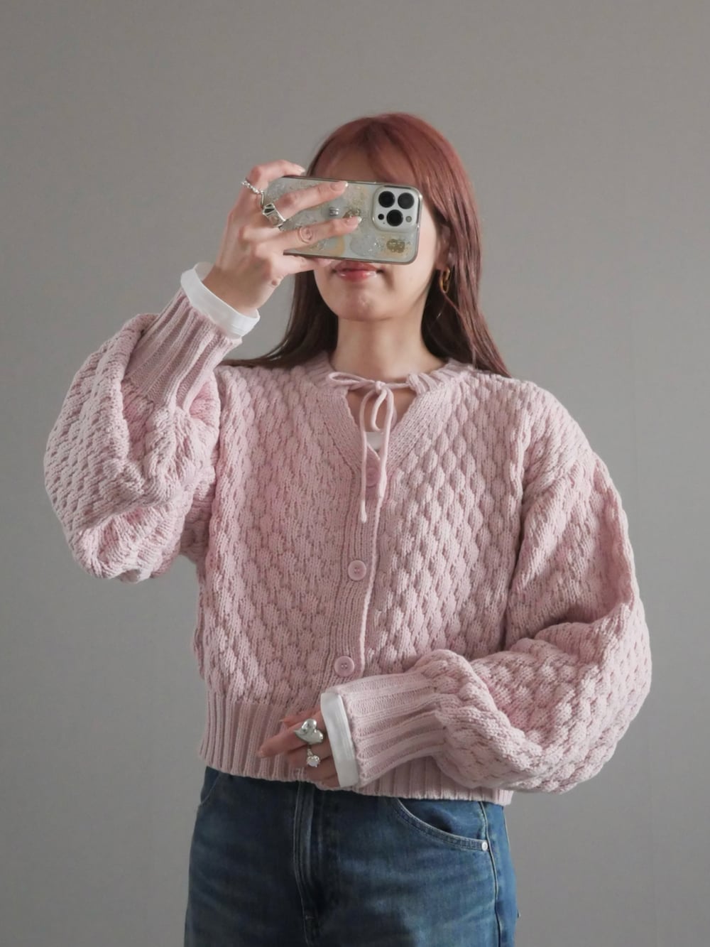 ピンク系のニット/セーター、ホワイト系のパンプス、ホワイト系のハンドバッグを着用したレディースの冬コーディネートの2枚目の写真