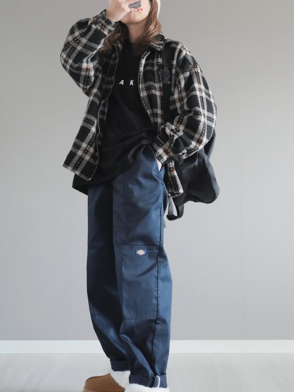 ブルー系のチノパンツ、ブラック系のブルゾン、ブラック系のTシャツ/カットソーを着用したレディースの冬コーディネートの2枚目の写真