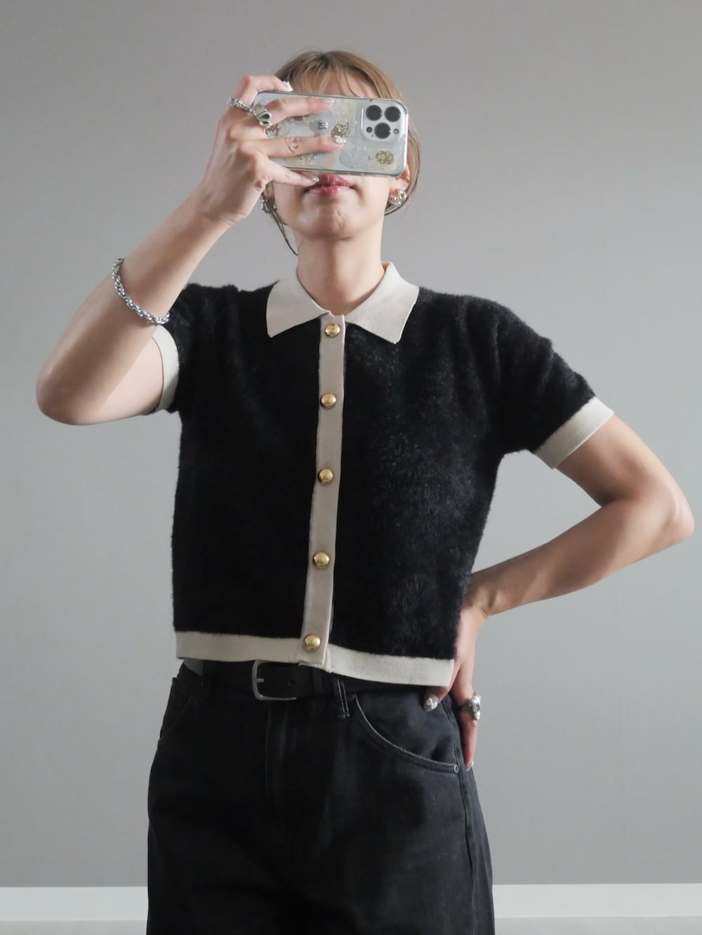 ブラック系のハンドバッグ、ブラック系のニット/セーター、シルバー系のリングを着用したレディースの秋コーディネートの2枚目の写真