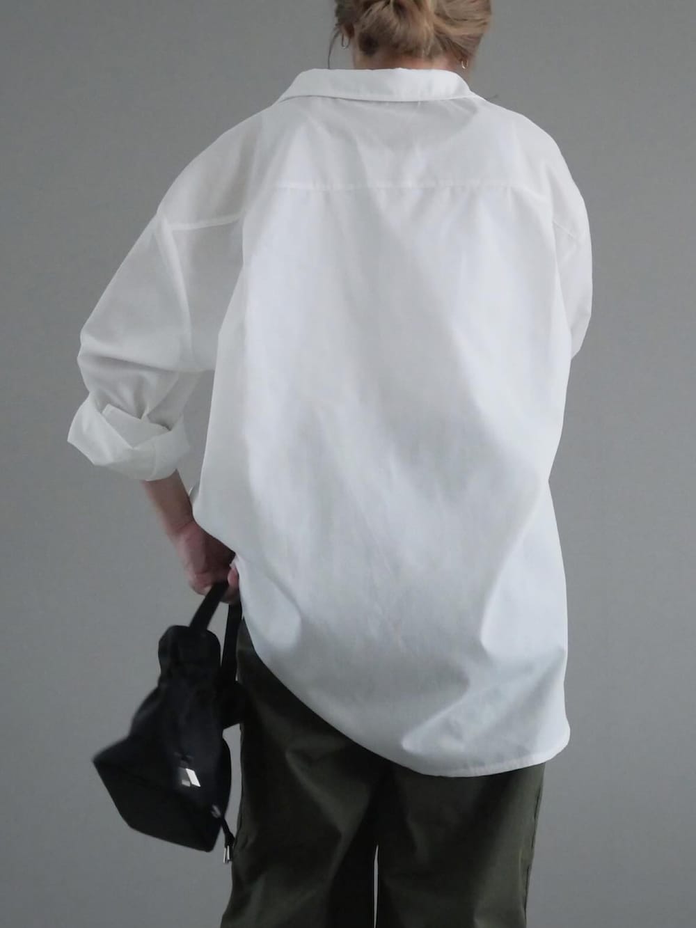 ホワイト系のシャツ/ブラウス、グリーン系のパンツ、ブラック系のバッグを着用したレディースの春コーディネートの3枚目の写真