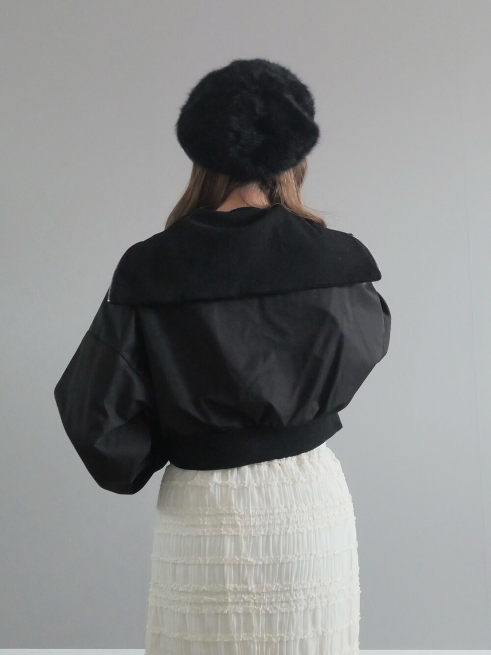 ブラック系のセットアップ、ホワイト系のスカート、ブラック系のショルダーバッグを着用したレディースの冬コーディネートの4枚目の写真