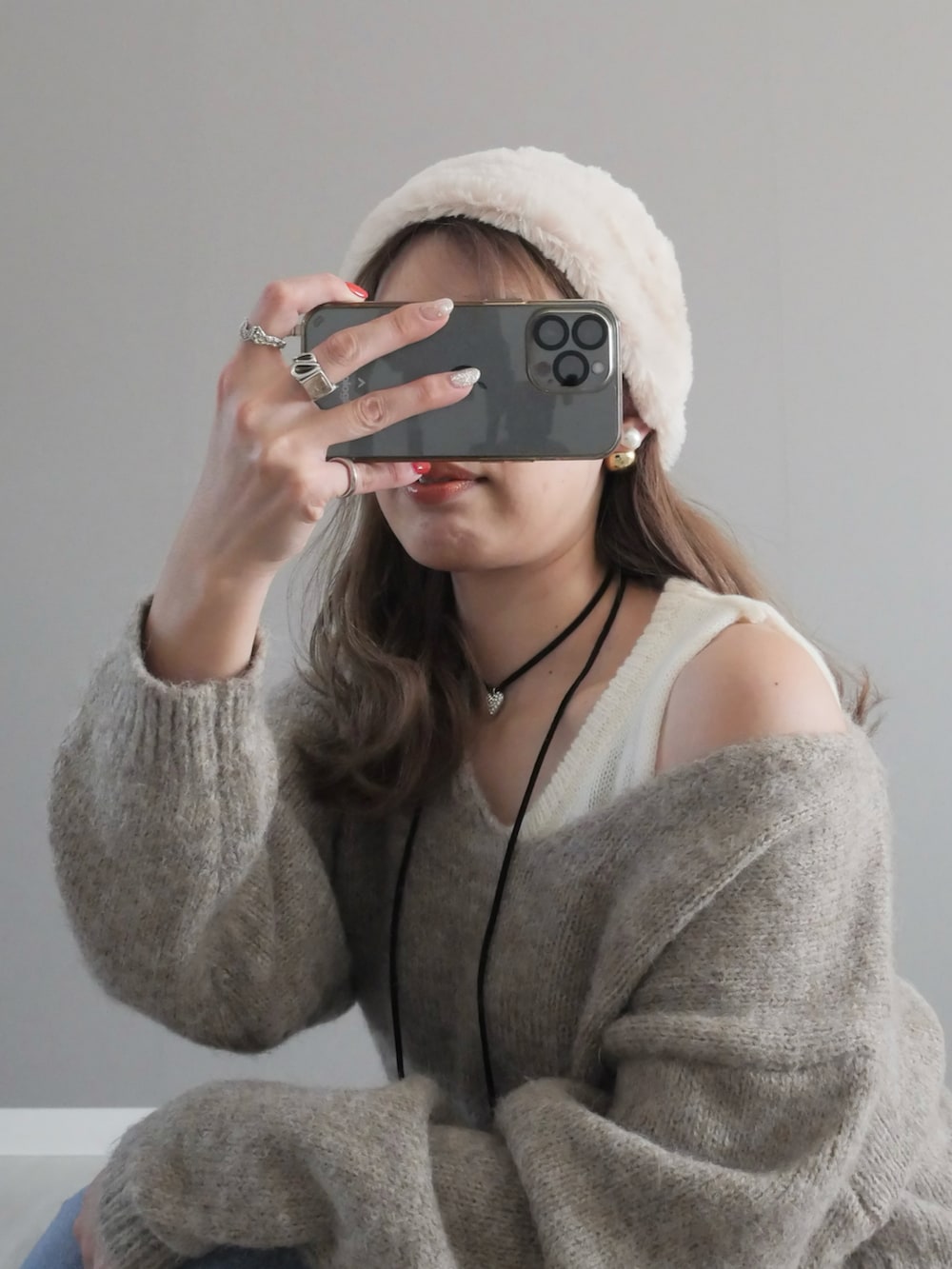 ブルー系のデニムパンツ、ベージュ系のニット/セーター、イエロー系のショルダーバッグを着用したレディースの冬コーディネートの3枚目の写真