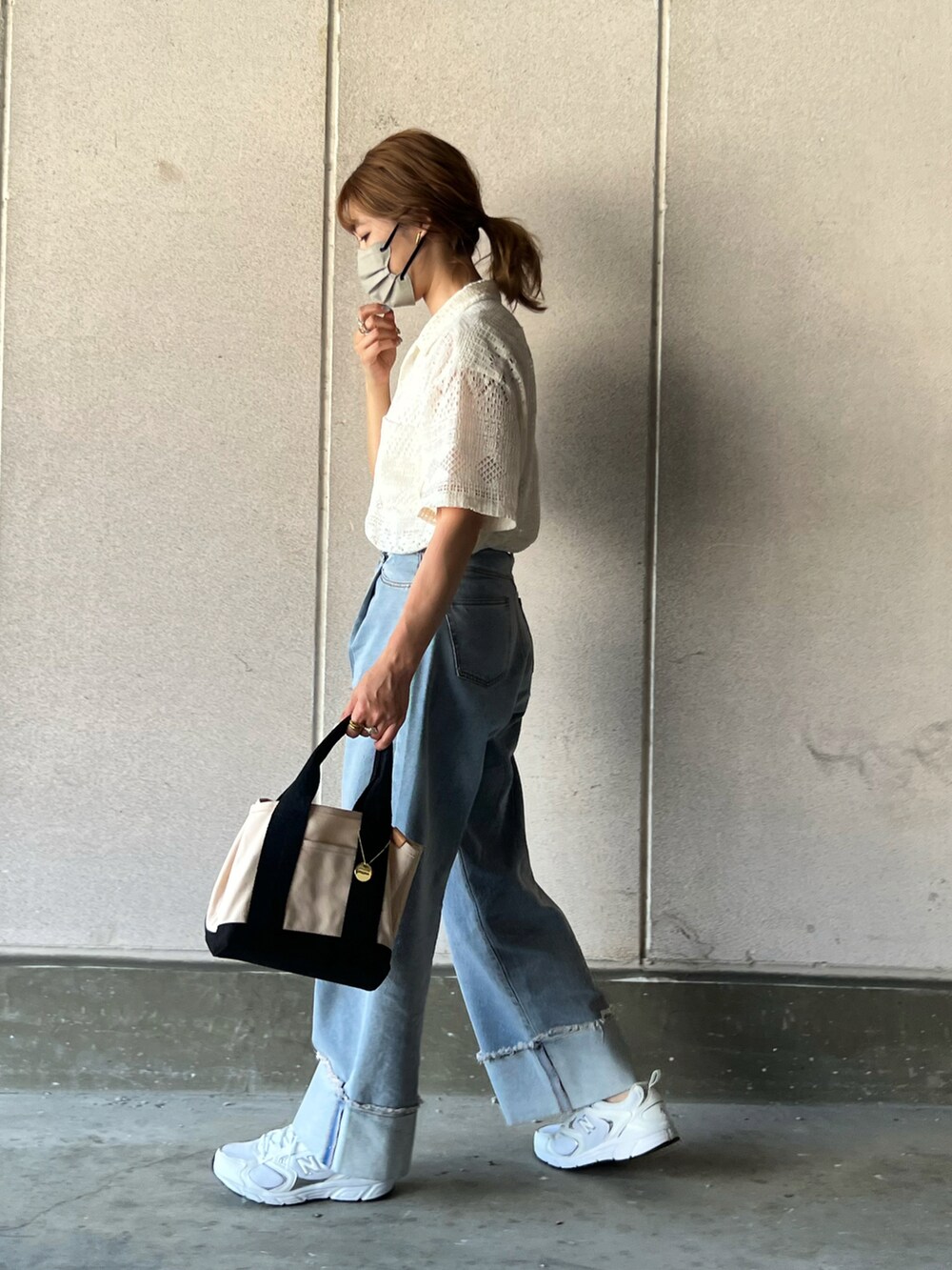 ホワイト系のトートバッグ、ホワイト系のシャツ/ブラウス、ブルー系のデニムパンツを着用したレディースの夏コーディネートの2枚目の写真