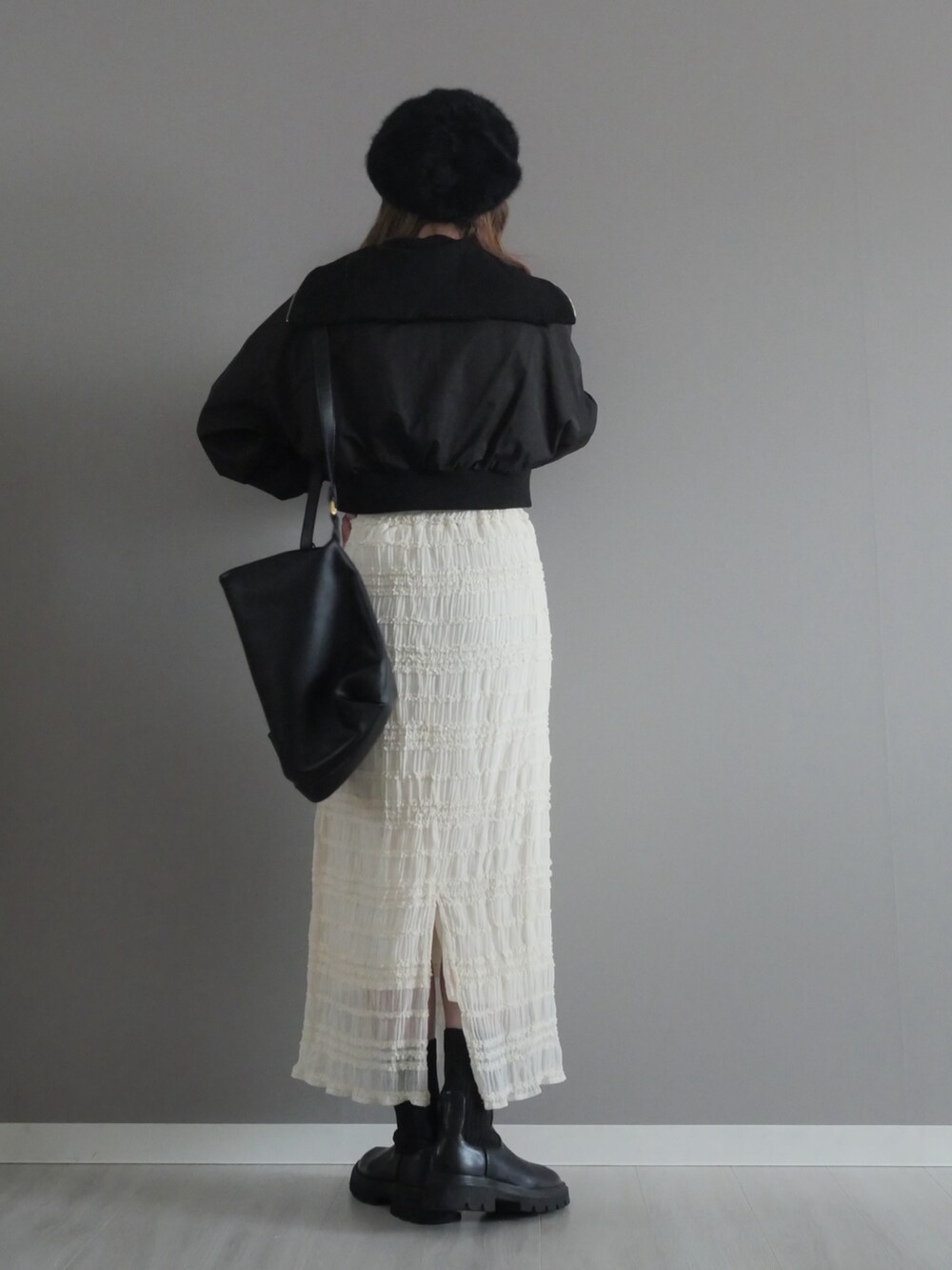 ブラック系のセットアップ、ホワイト系のスカート、ブラック系のショルダーバッグを着用したレディースの冬コーディネートの5枚目の写真