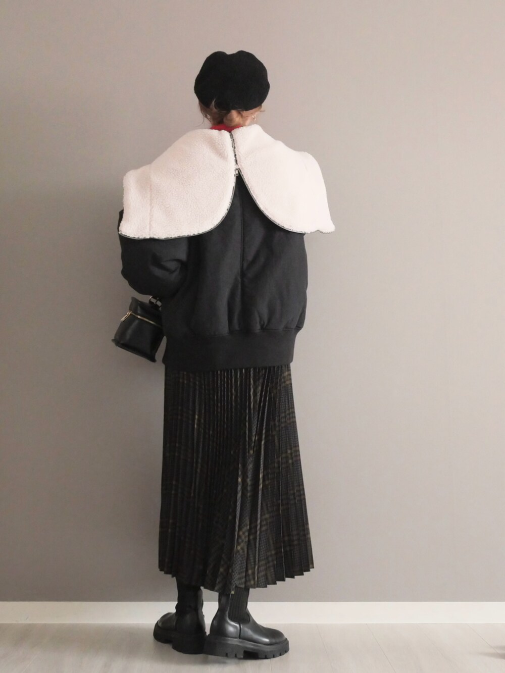 ブラック系のブルゾン、グレー系のスカート、ブラック系のショルダーバッグを着用したレディースの秋コーディネートの5枚目の写真