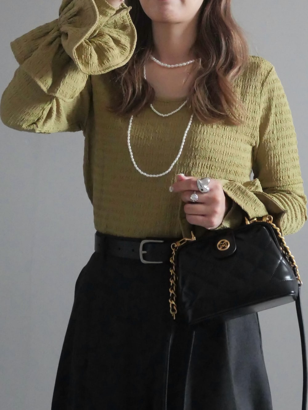 ブラック系のトートバッグ、グリーン系のTシャツ/カットソー、ブラック系のブーツを着用したレディースの秋コーディネートの2枚目の写真