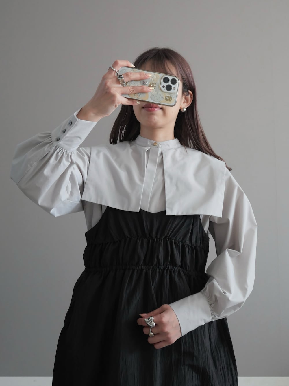 グレー系のシャツ/ブラウス、ブラック系のトートバッグ、ブラック系のブーツを着用したレディースの春コーディネートの2枚目の写真