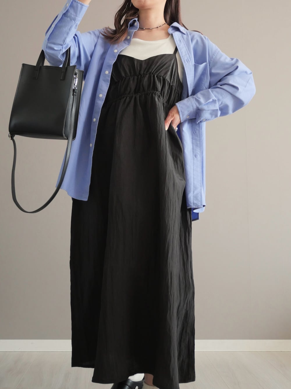 ホワイト系のタンクトップ、ブラック系のワンピース、ブラック系のショルダーバッグを着用したレディースの春コーディネートの2枚目の写真