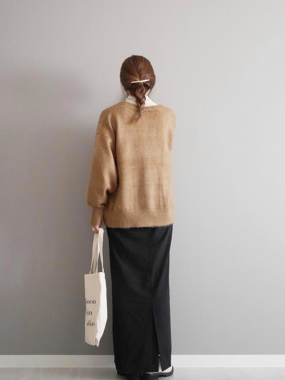 ブラウン系のカーディガン/ボレロ、ブラック系のワンピース、ホワイト系のローファーを着用したレディースの秋コーディネートの2枚目の写真