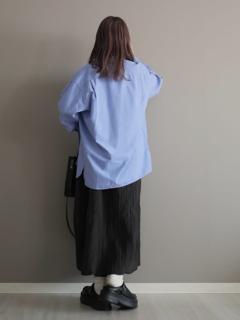 ホワイト系のタンクトップ、ブラック系のワンピース、ブラック系のショルダーバッグを着用したレディースの春コーディネートの4枚目の写真