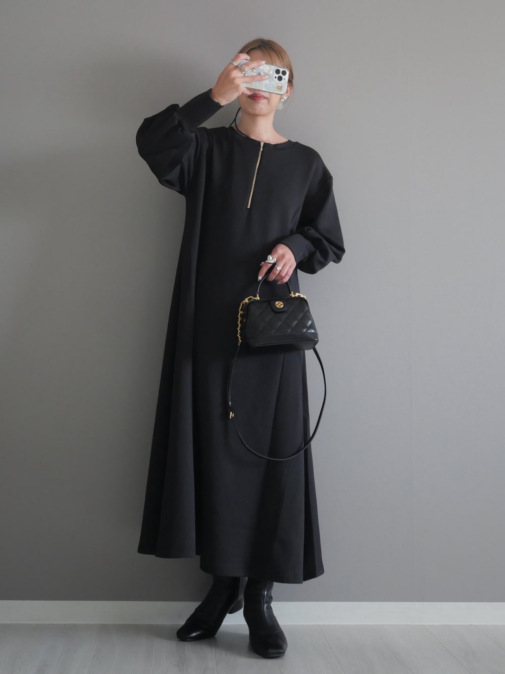 ブラック系のトートバッグ、ブラック系のワンピース、ブラック系のブーツを着用したレディースの秋コーディネートの2枚目の写真