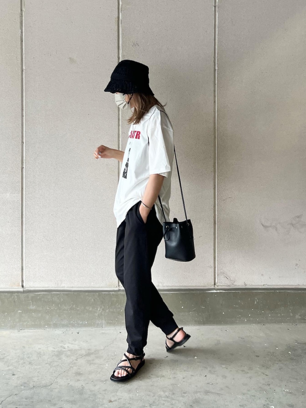 ホワイト系のTシャツ/カットソー、ブラック系のパンツ、ブラック系のバッグを着用したレディースの春コーディネートの3枚目の写真