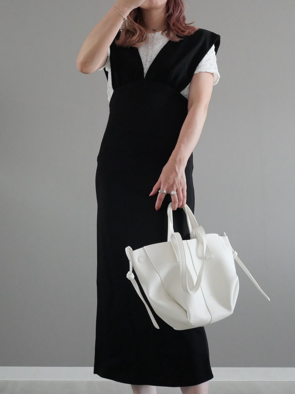 ブラック系のワンピース、ホワイト系のショルダーバッグ、ホワイト系のサンダルを着用したレディースの夏コーディネートの2枚目の写真