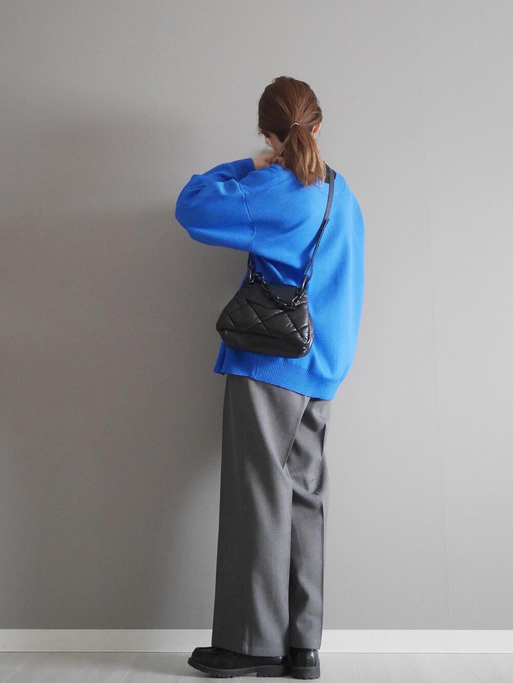 ブルー系のカーディガン/ボレロ、ブラック系のトップス、グレー系のパンツを着用したレディースの冬コーディネートの2枚目の写真