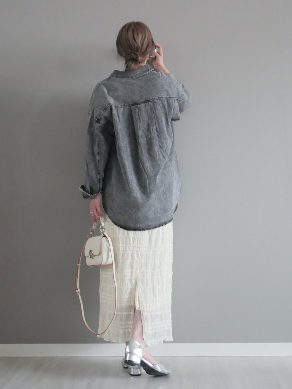 ブラック系のシャツ/ブラウス、ホワイト系のスカート、ホワイト系のハンドバッグを着用したレディースの春コーディネートの3枚目の写真