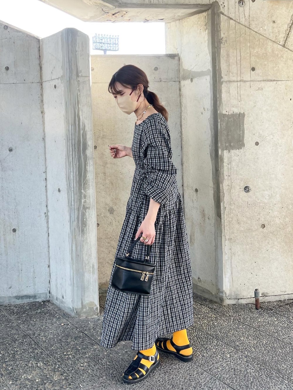 ブラック系のワンピース、ブラック系のショルダーバッグ、ブラック系のサンダルを着用したレディースの春コーディネートの3枚目の写真