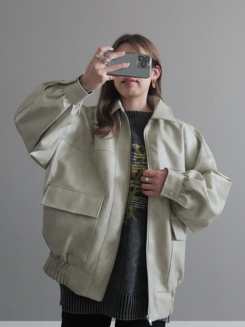 ホワイト系のブルゾン、ブラック系のニット/セーター、ブラック系のその他パンツを着用したレディースの冬コーディネートの3枚目の写真