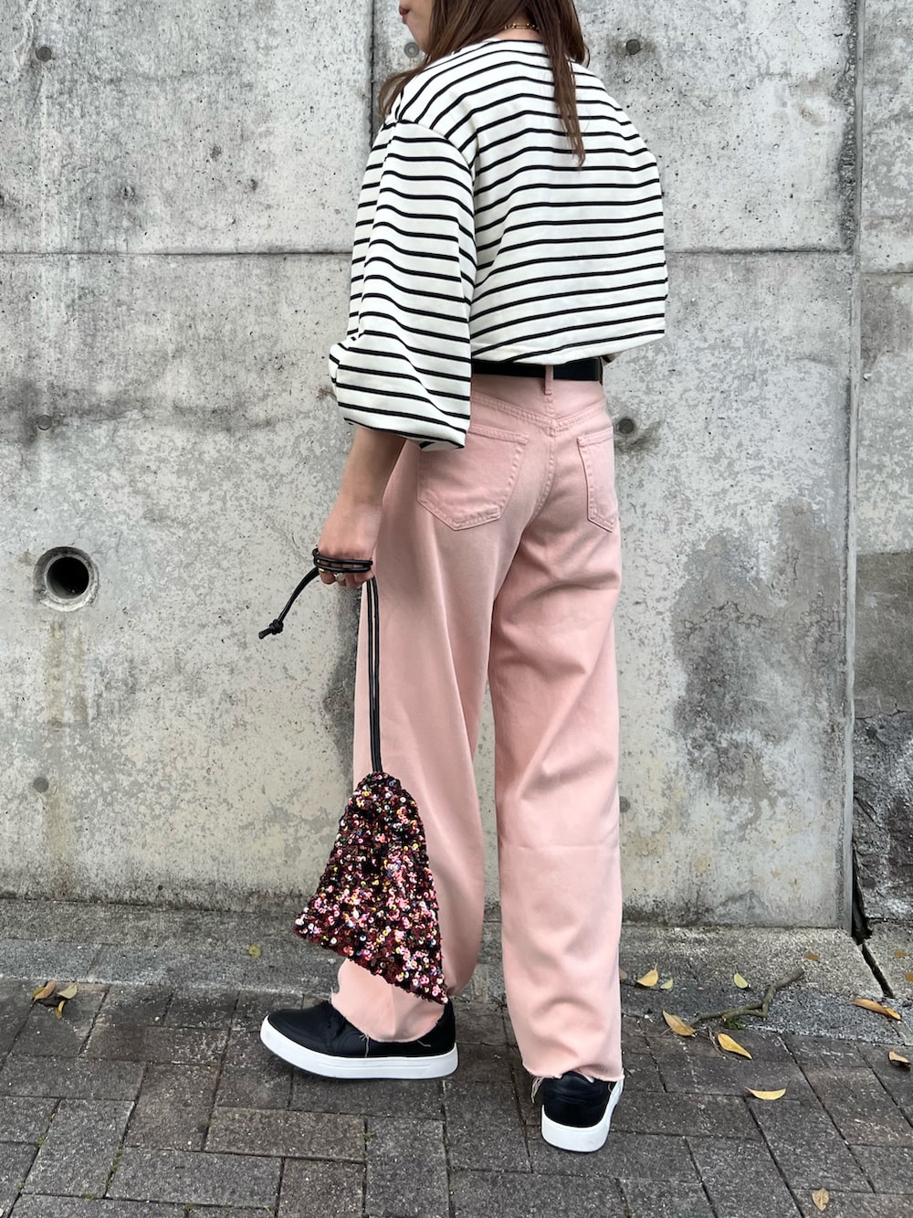 ホワイト系のスウェット、ピンク系のパンツ、レッド系のショルダーバッグを着用したレディースの春コーディネートの3枚目の写真