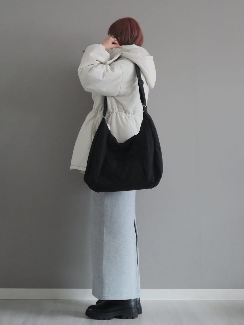 ホワイト系のダウンジャケット/コート、ブラック系のブーツ、ブラック系のTシャツ/カットソーを着用したレディースの冬コーディネートの3枚目の写真