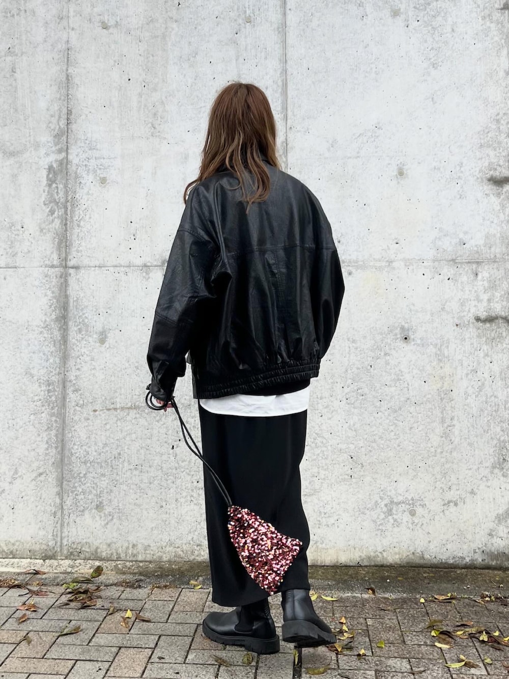 レッド系のショルダーバッグ、ブラック系のトップス、ホワイト系のシャツ/ブラウスを着用したレディースの冬コーディネートの4枚目の写真