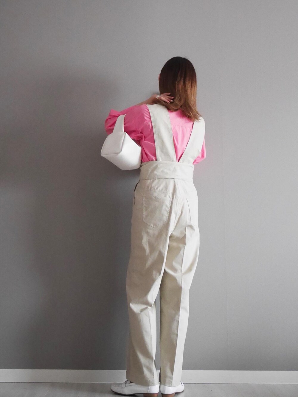 ピンク系のシャツ/ブラウス、ベージュ系のサロペット/オーバーオール、ホワイト系のボストンバッグを着用したレディースの春コーディネートの2枚目の写真