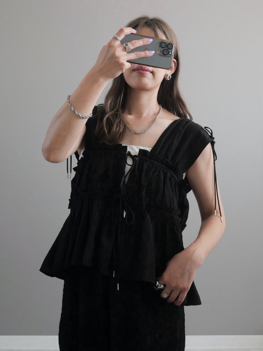 ブラック系のシャツ/ブラウス、ブラック系のショルダーバッグ、ブラック系のサンダルを着用したレディースの夏コーディネートの2枚目の写真